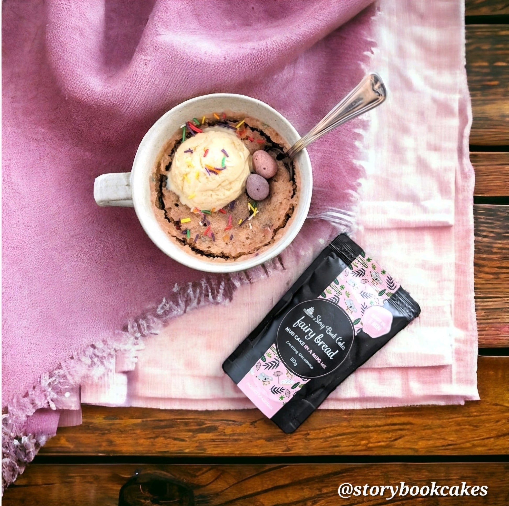 Mug cake with ice cream and toppings on a pink cloth